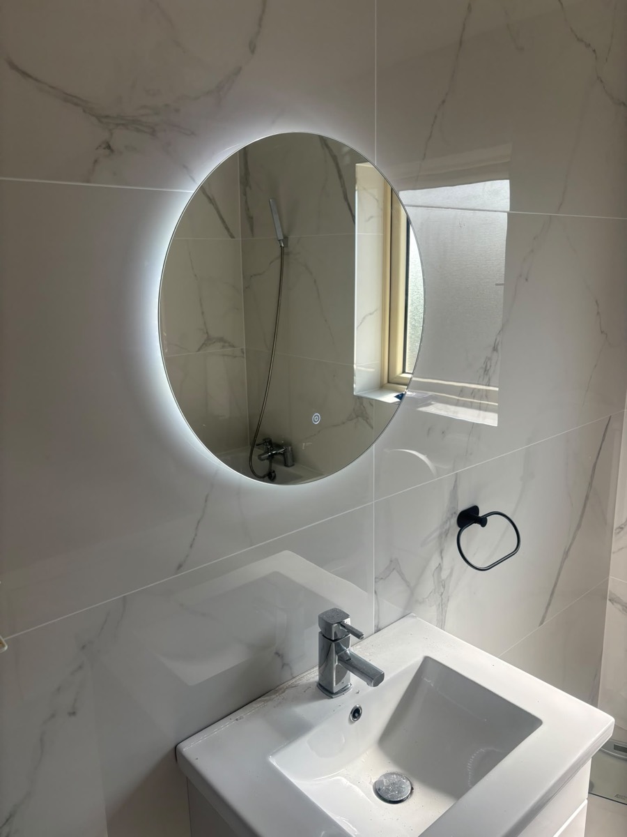 Backlit round mirror installation, marble bathroom, Cork
